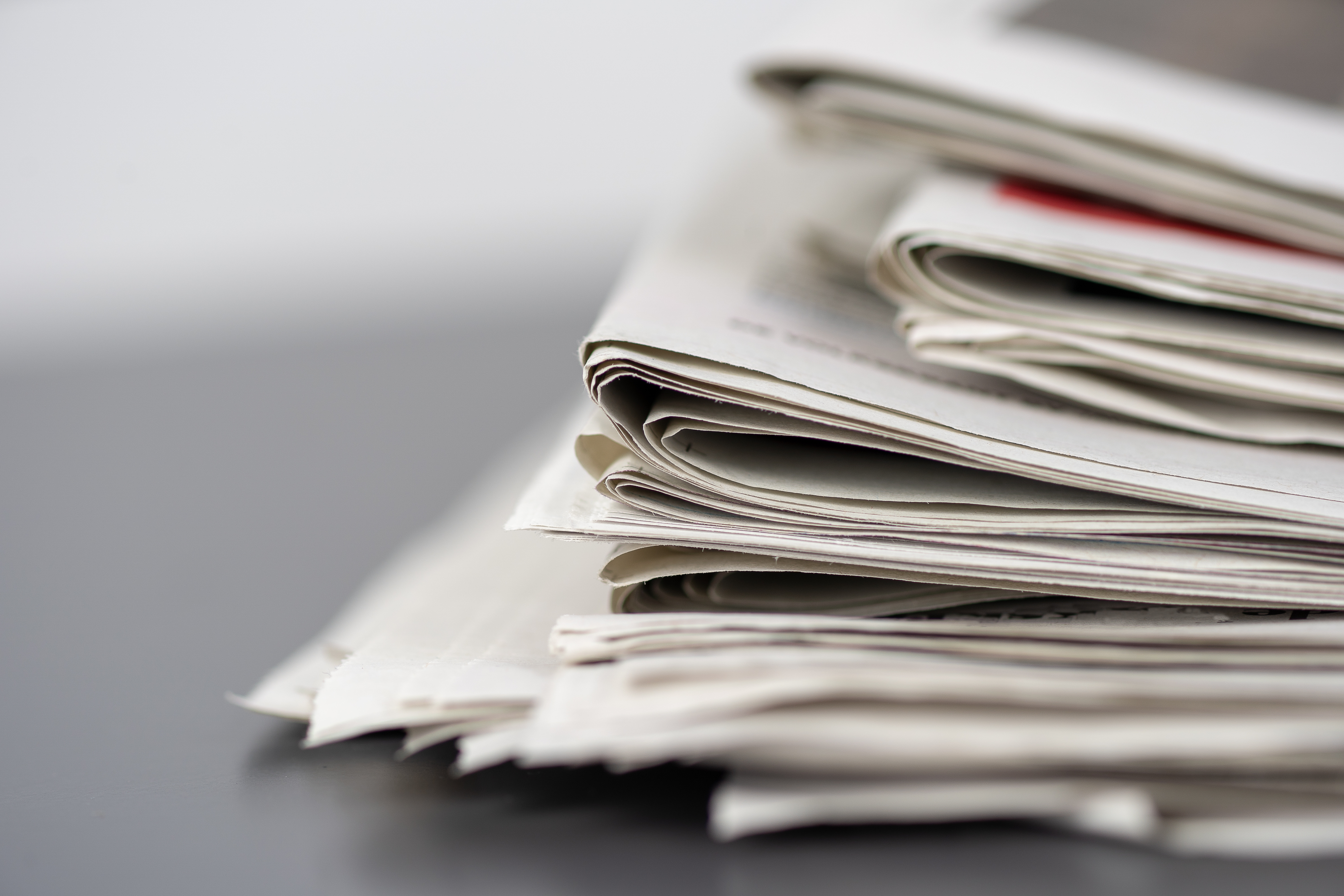 Closeup Shot Of Several Newspapers Stacked On Top Of Each Other