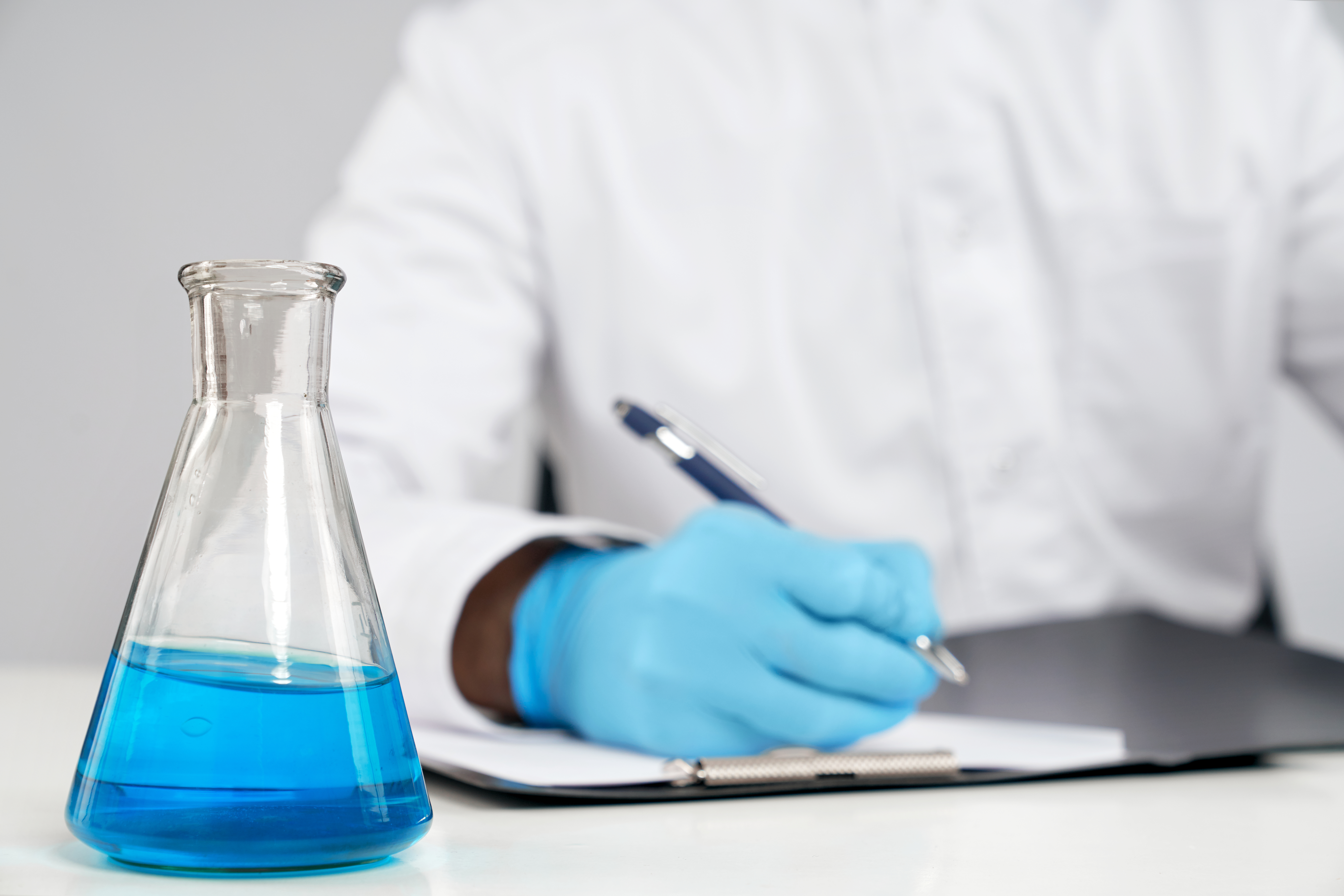Chemist Writing Report, Flask Nearby.