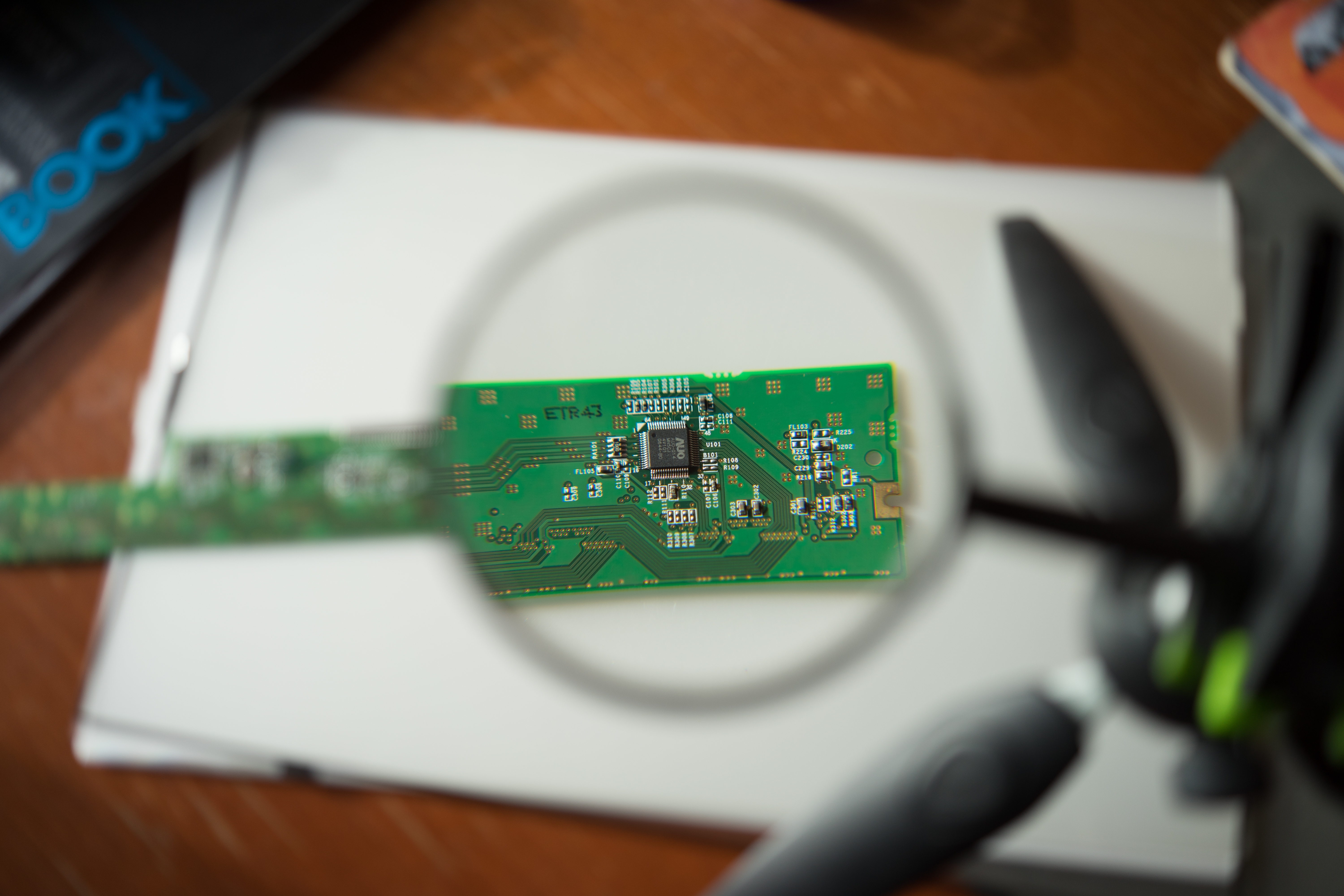 Engineer Looking At A Circuit Board Through A Magnifying Glass